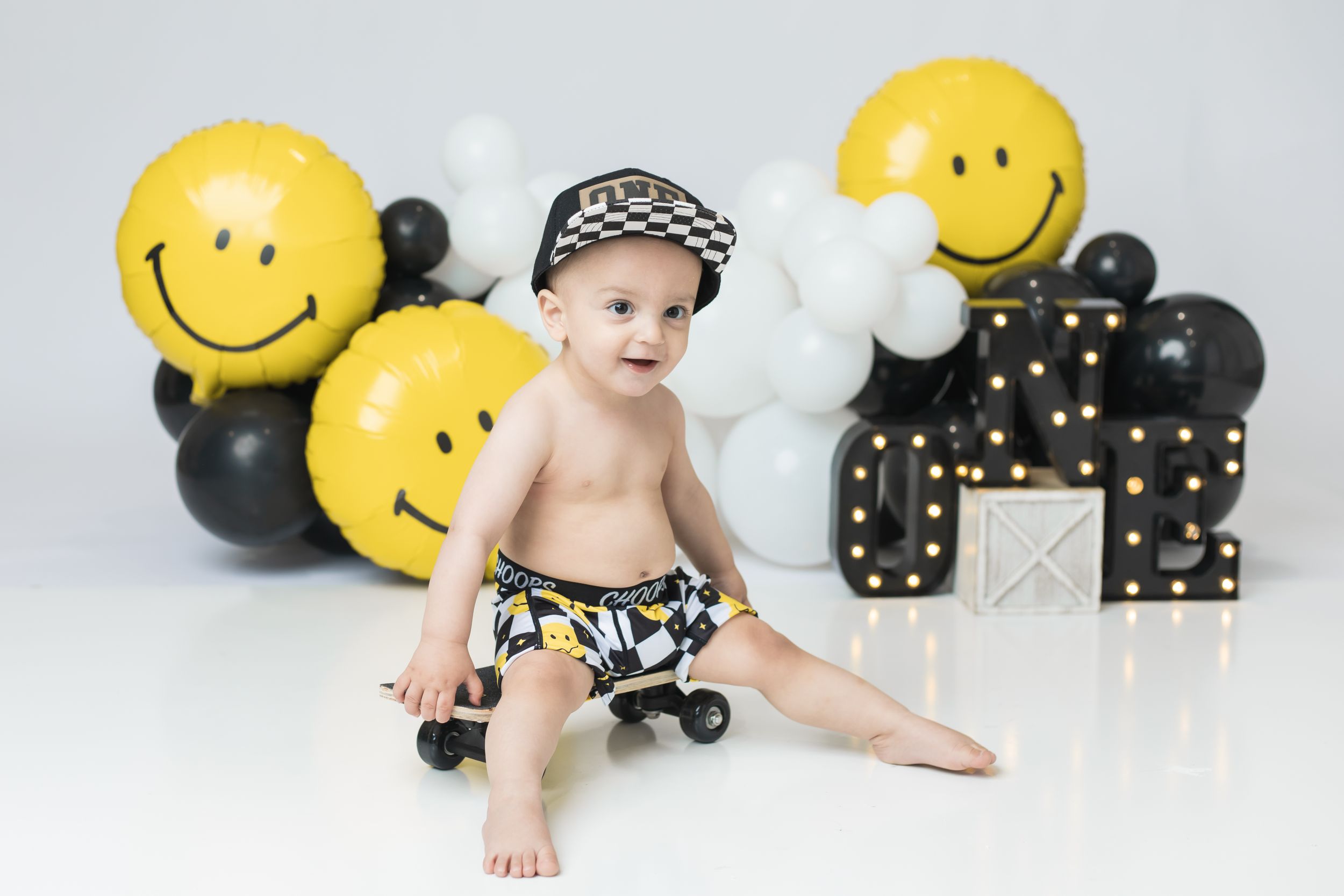 Adorable cake smash session: Baby gleefully smashing a colorful cake during a fun photoshoot
