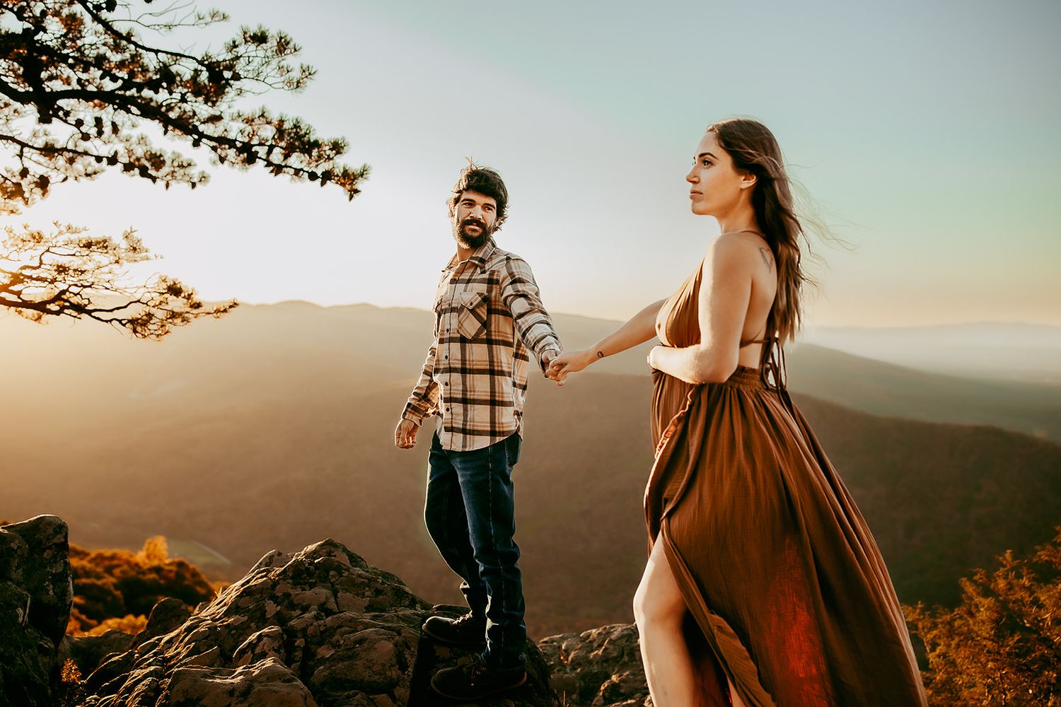 A husband and wife hold hands at Raven's Roost Overlook during their maternity photoshoot.