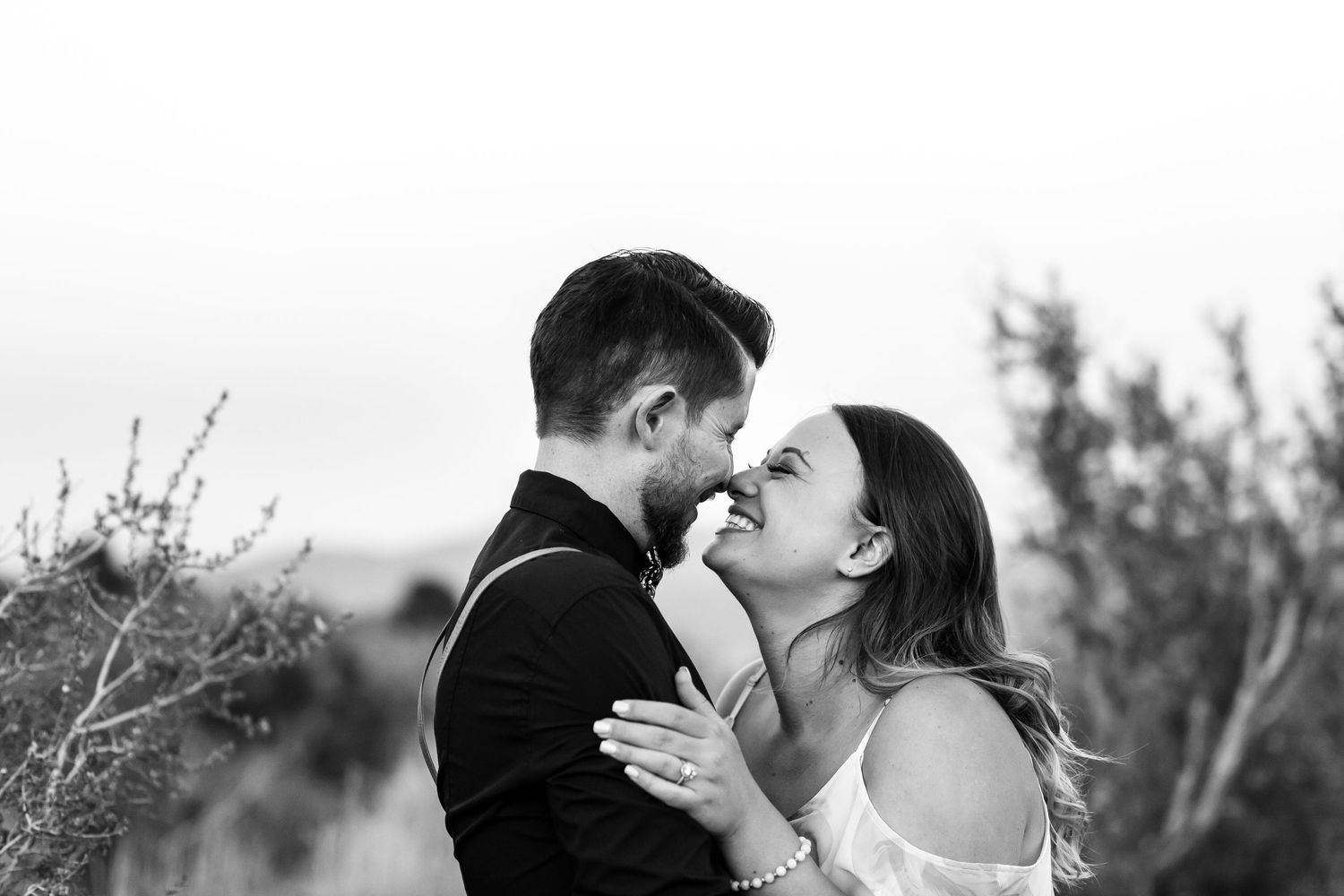 Black and white intimate portrait of couple in desert landscape.