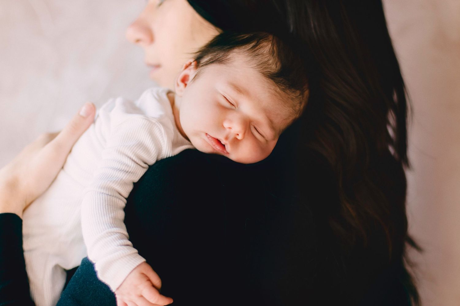 newborn across moms shoulders