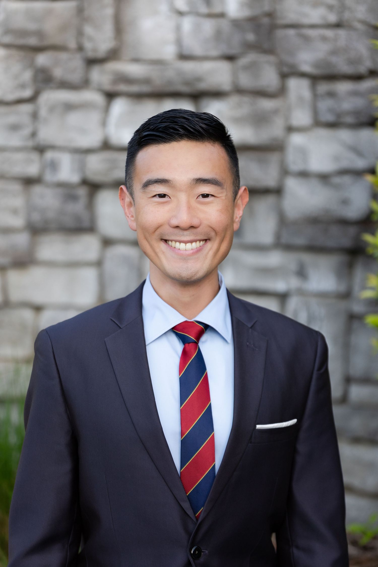 headshot of man in suit in front of rock wall in folsom, california