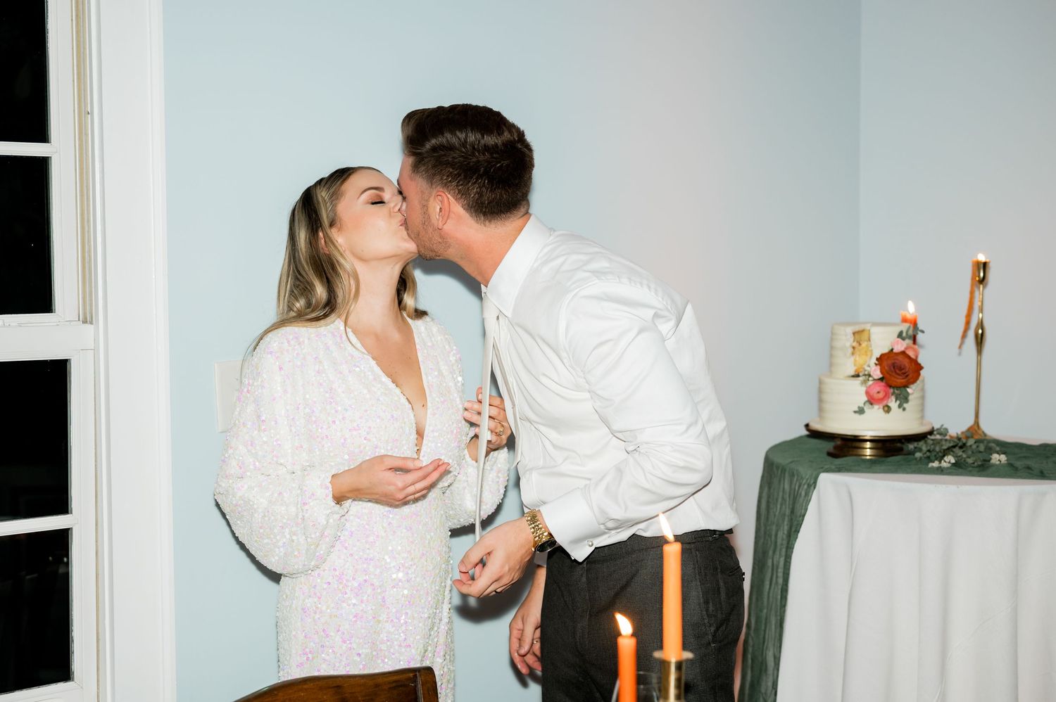 Romantic wedding reception moments captured during cake cutting tradition.