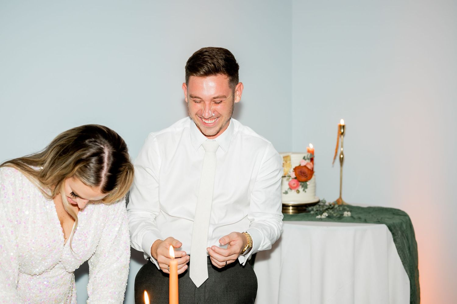 Playful cake cutting sequence at an intimate wedding reception.
