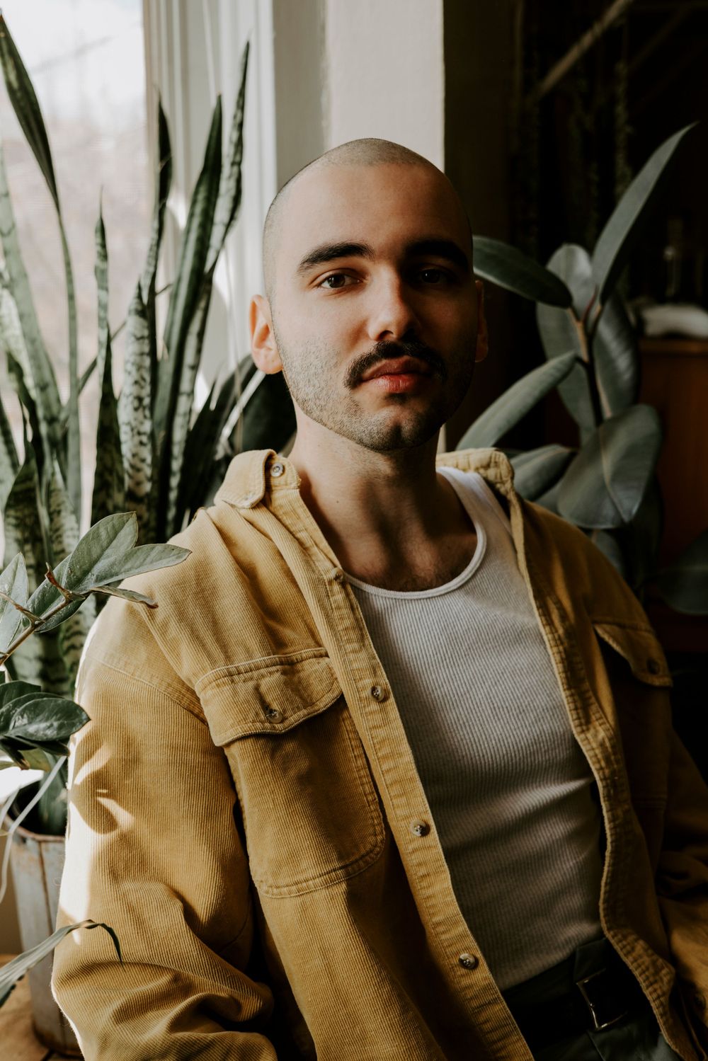 Casual indoor scene with tan jacket and houseplants creating a cozy atmosphere.