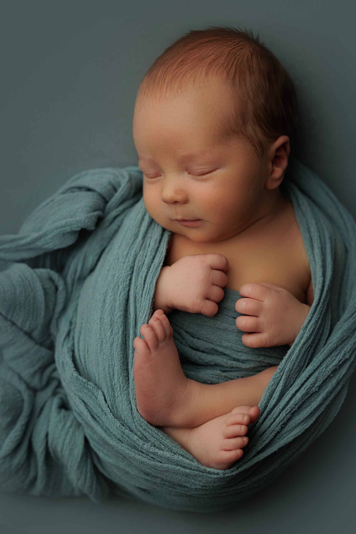 baby som ligger og sover og har det behagelig med blått teppe