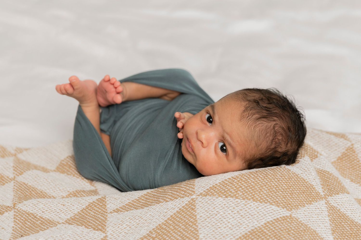 newborn baby boy wrapped in a blue wrap in huck Finn by an Oakland county lifestyle photographer