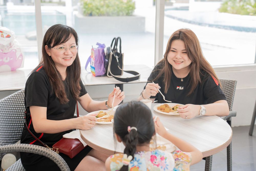 Group enjoying casual meal together at bright restaurant table.