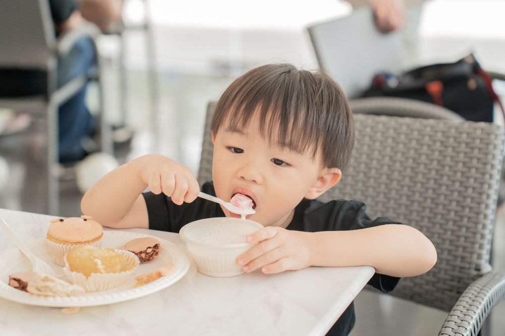 Child eating from bowl at restaurant table.
