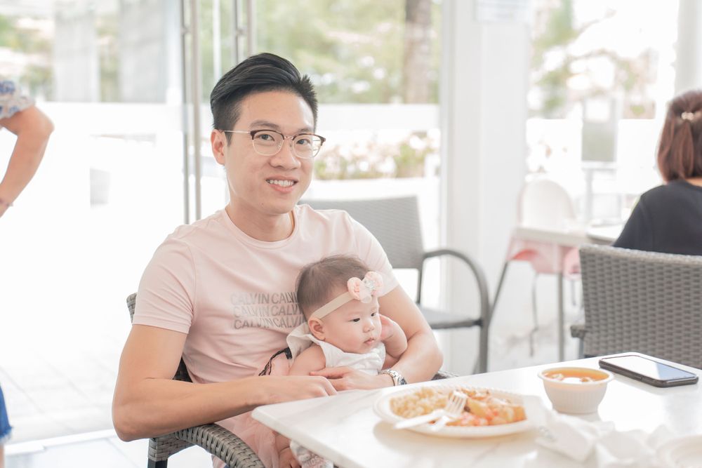 A parent and child sitting at a cafe table with food.