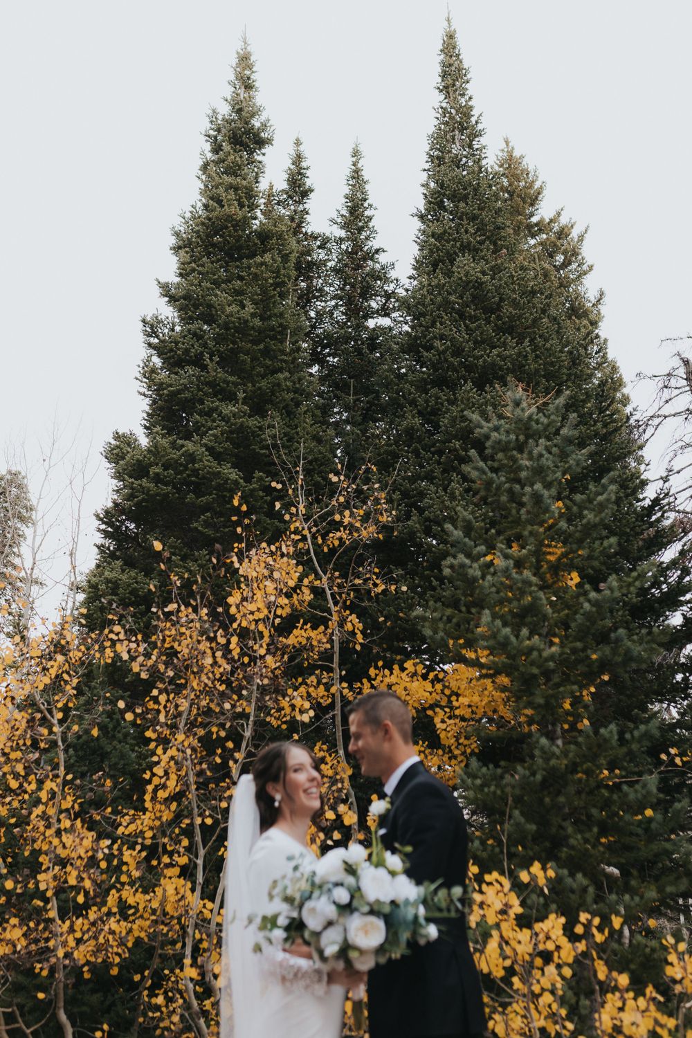 Talented luxury wedding photographer captures bride and groom in the fall foliage of Big Cottonwood Canyon, Utah.