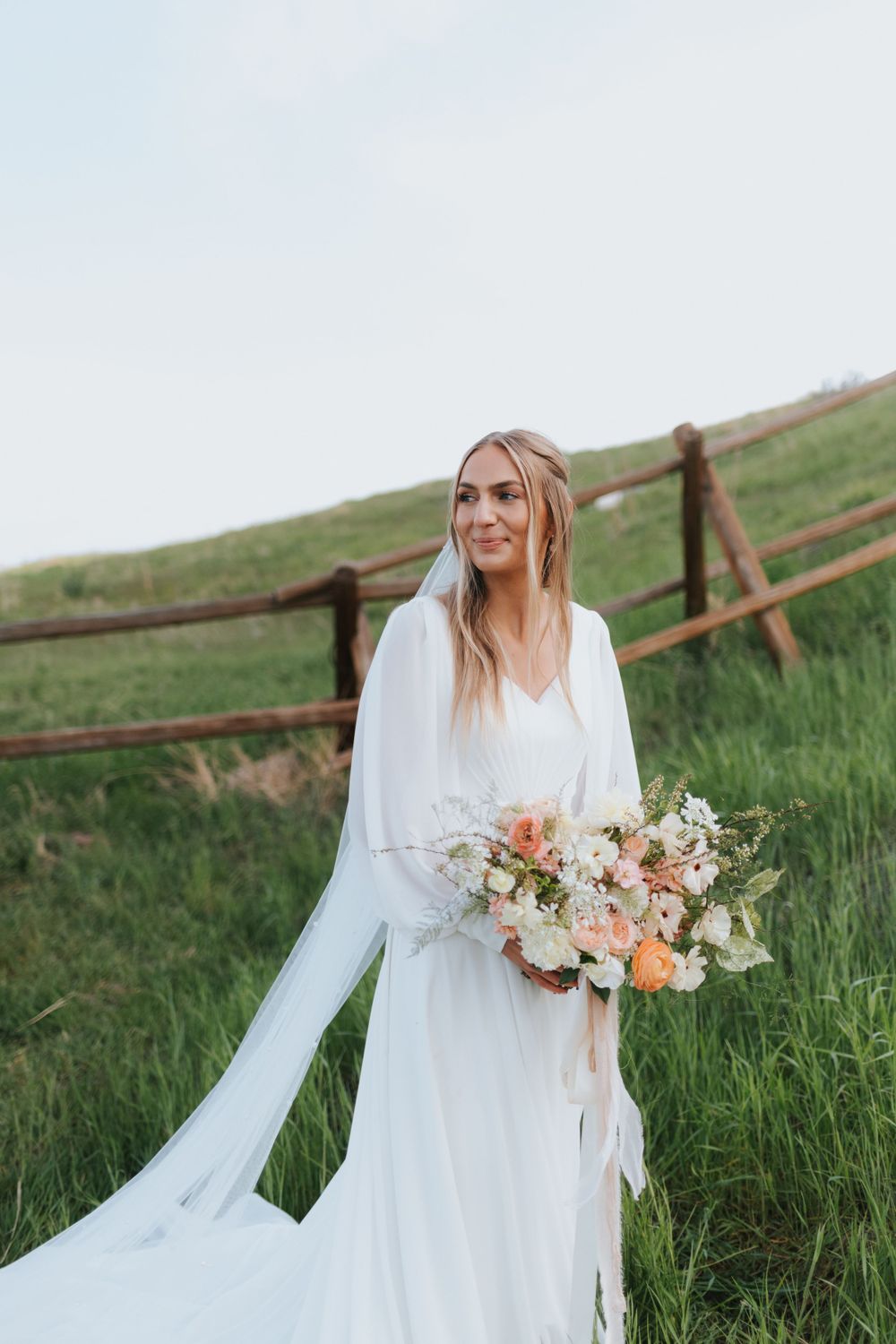 Bride smiles and looks off in the distance as she works with her luxury wedding photographer.