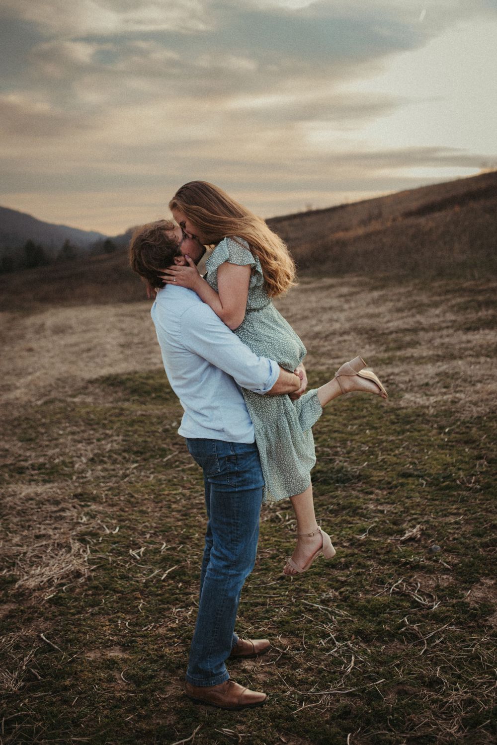Romantic sunset moment in an open field with dramatic sky.