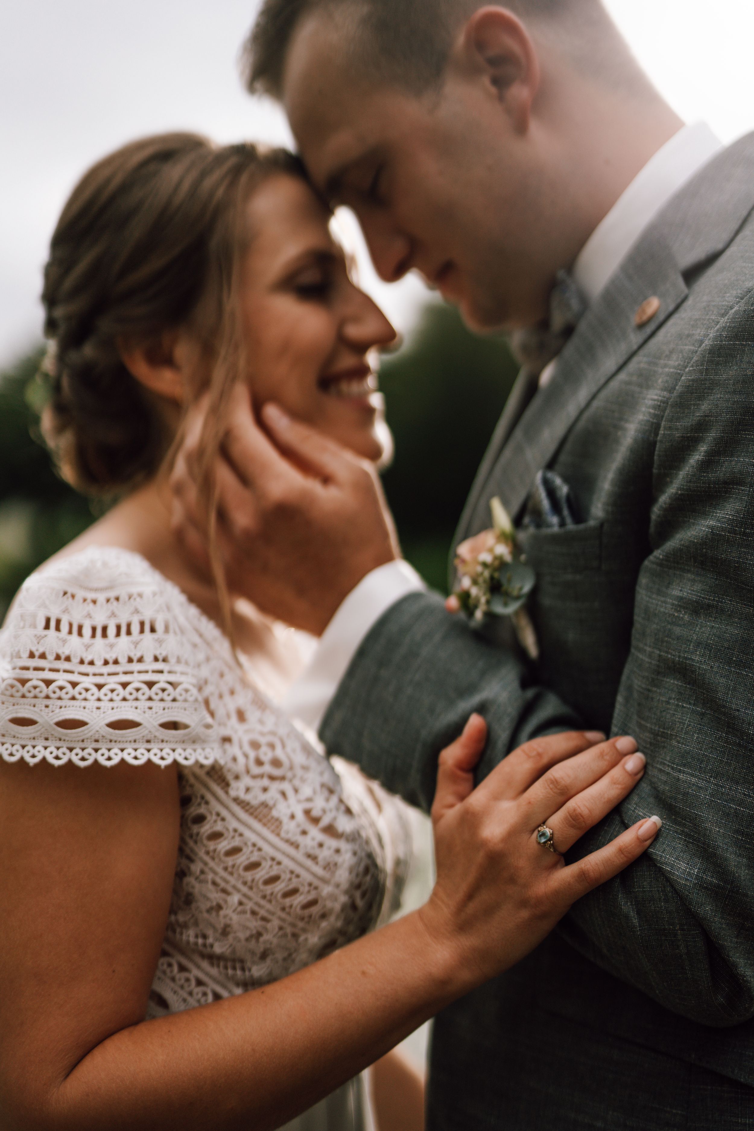Close-up wedding portrait showing lace dress detail and joyful emotional expressions.