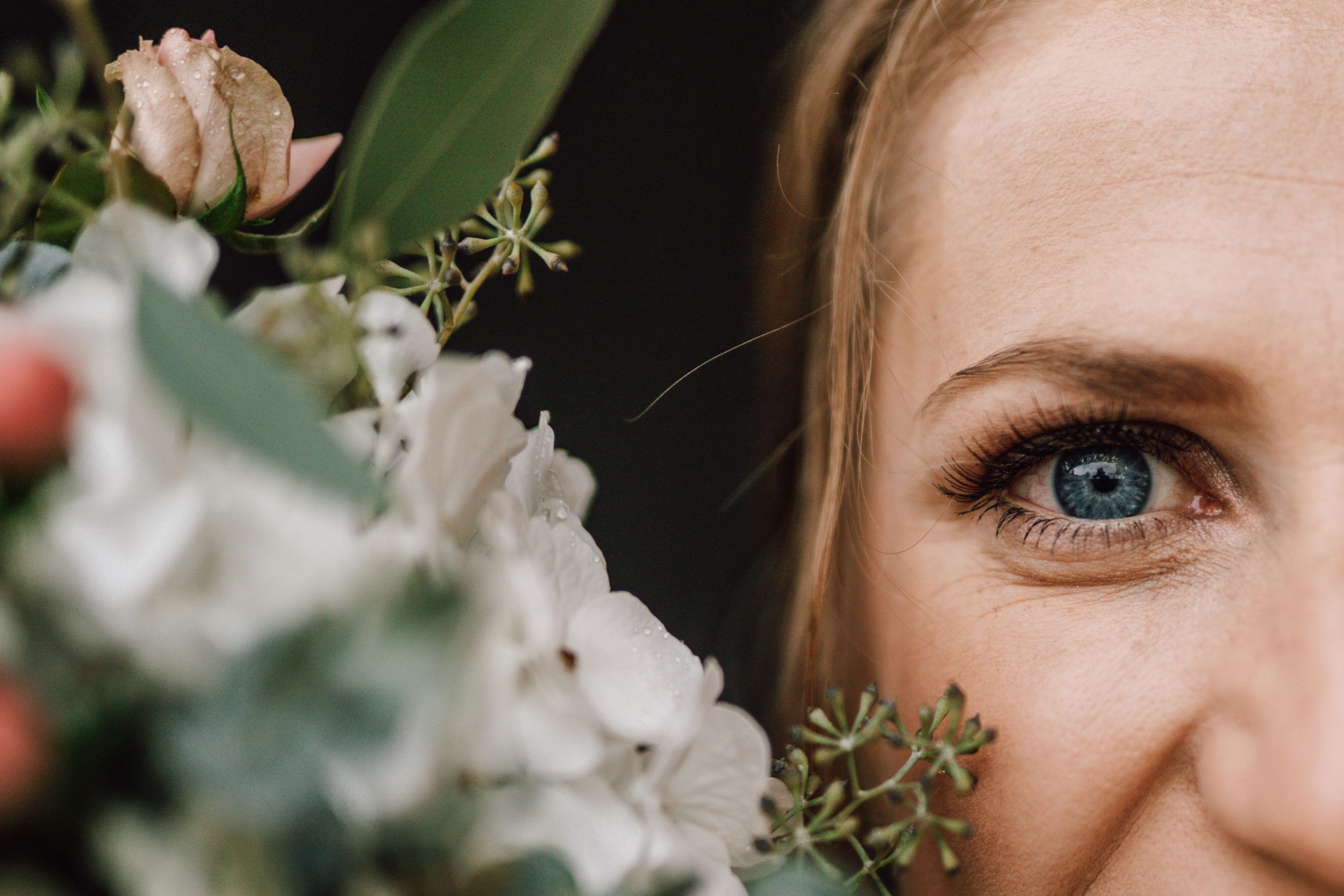 Artistic close-up detail of bridal bouquet with soft white flowers.