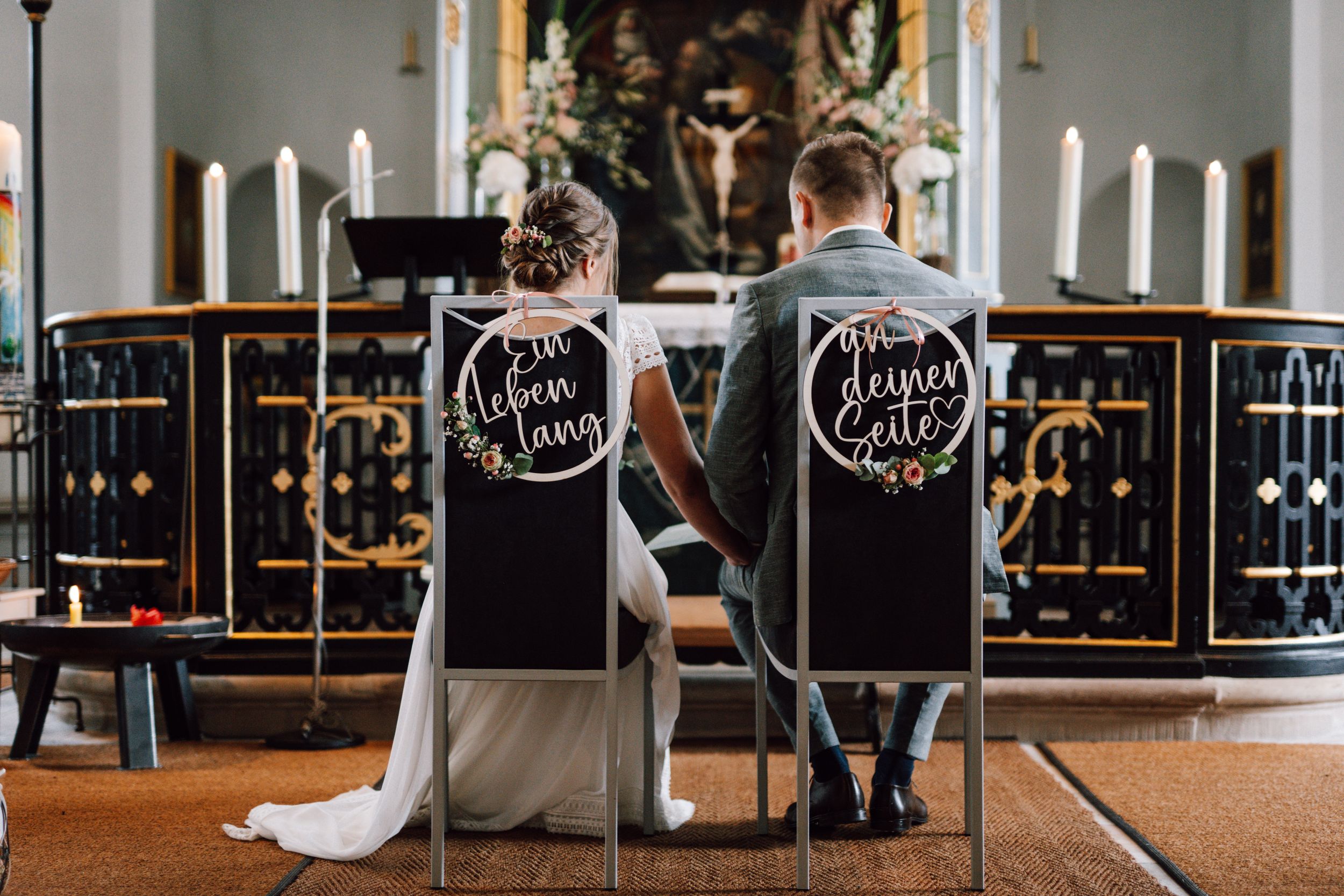 Couple sitting in church pews wearing matching 'Better Together' black shirts.
