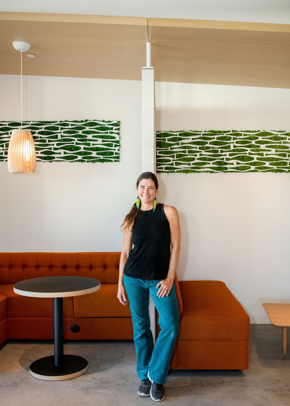 portrait of terra malia of lush elements in front of her living wall design