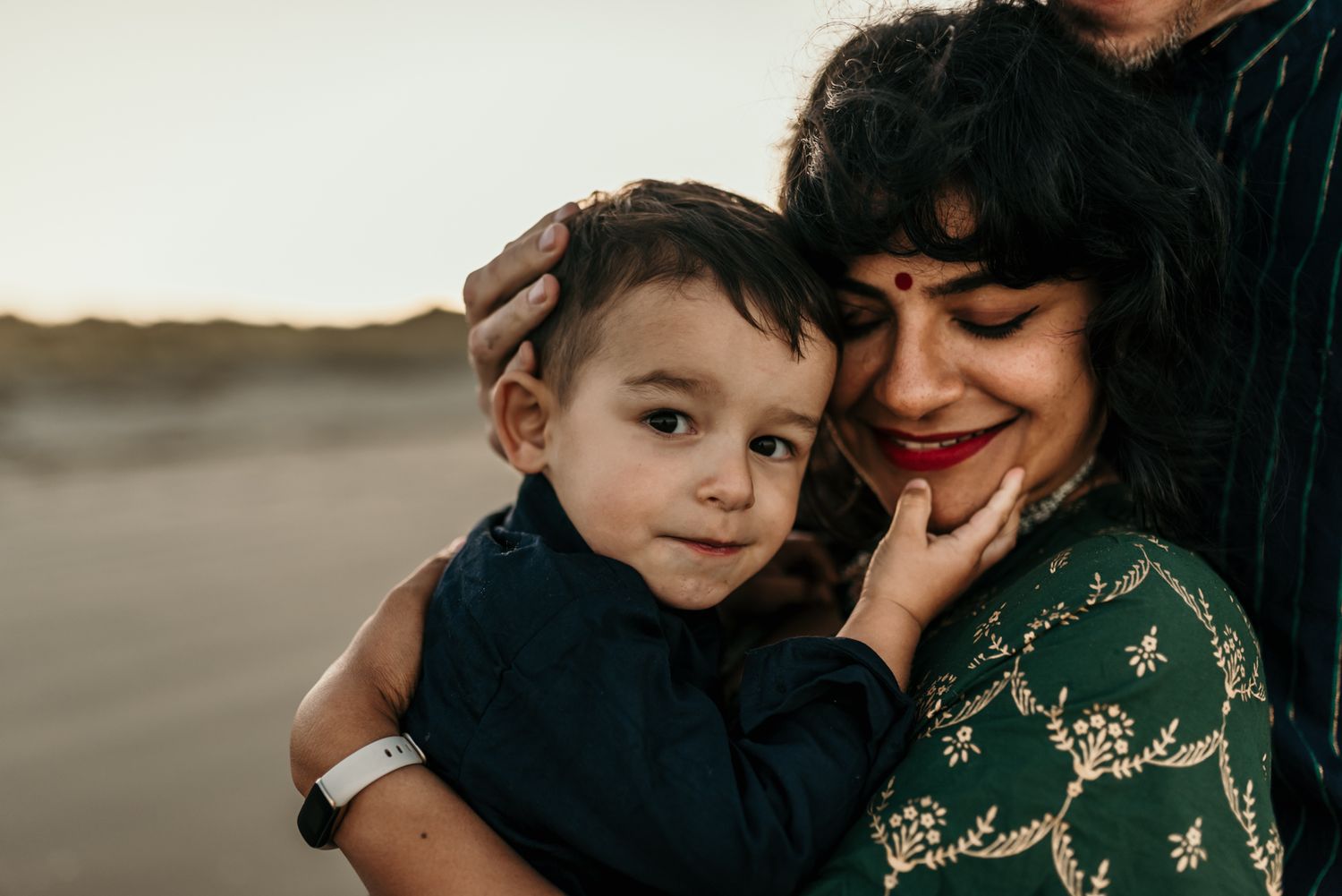 Tender family moment captured during golden hour at the beach.
