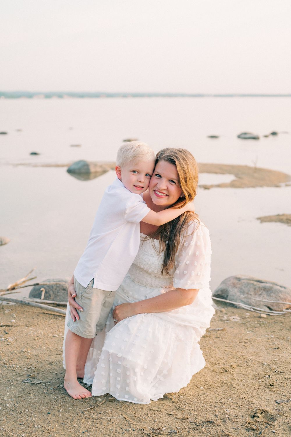 A sweet embrace captured on a rocky beach during golden hour.