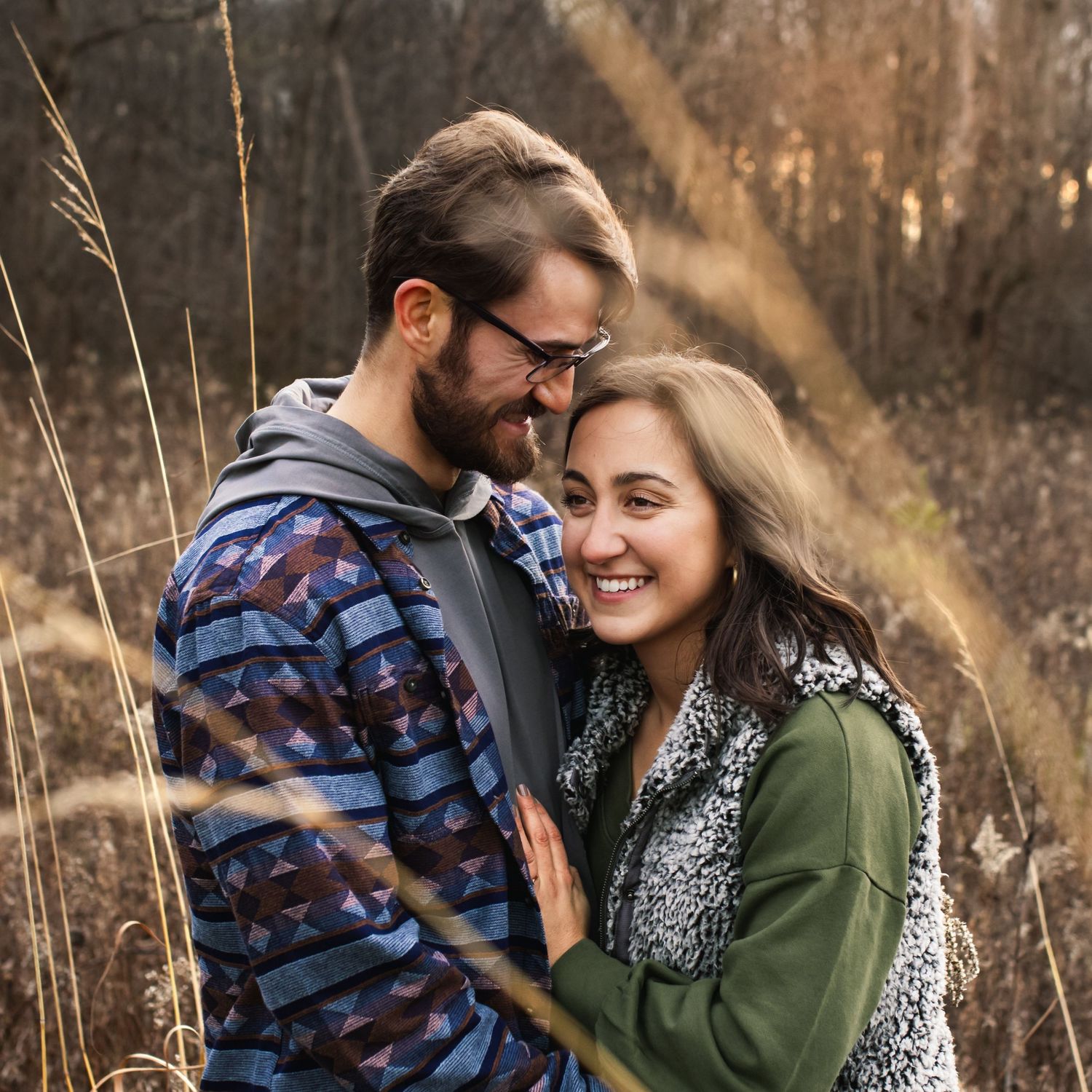 couple in earthy colors laughing in tall grass