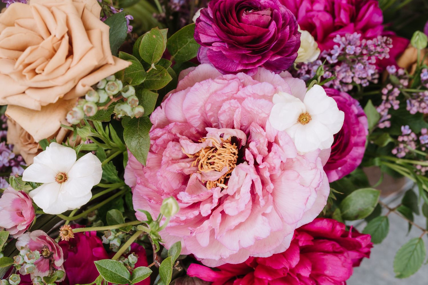 Vibrant floral arrangement featuring pink, magenta and peach roses with white accents.