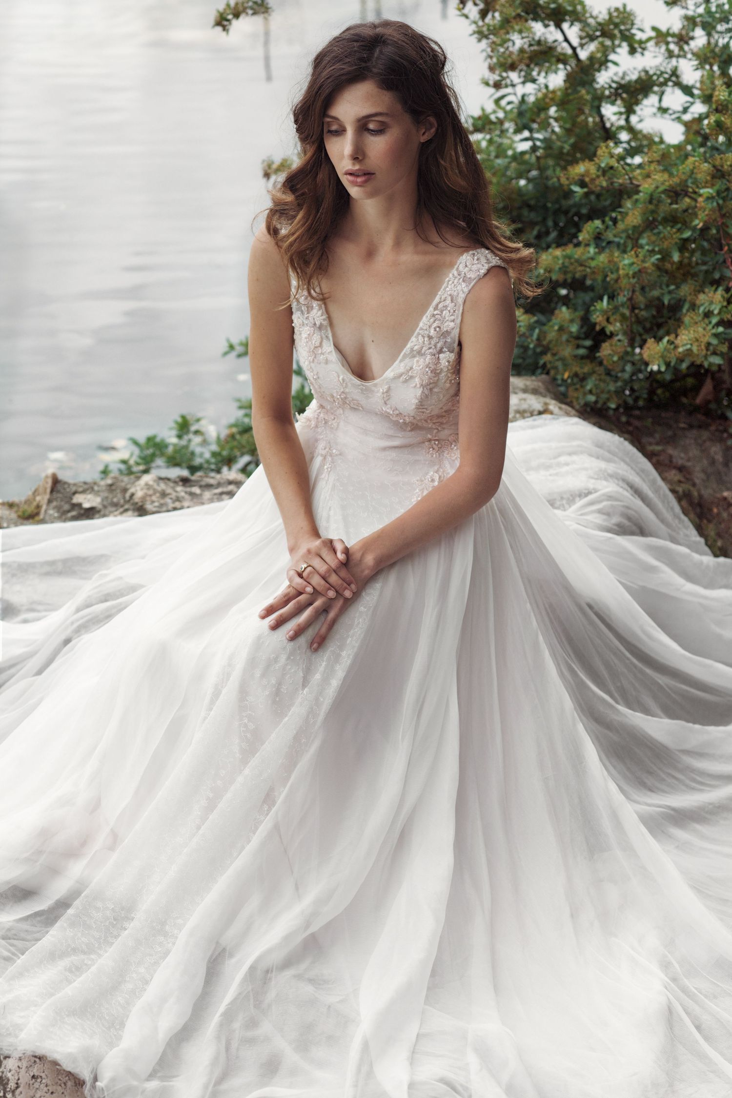 Stunning bridal gown with lace bodice and flowing tulle skirt in an outdoor garden setting.