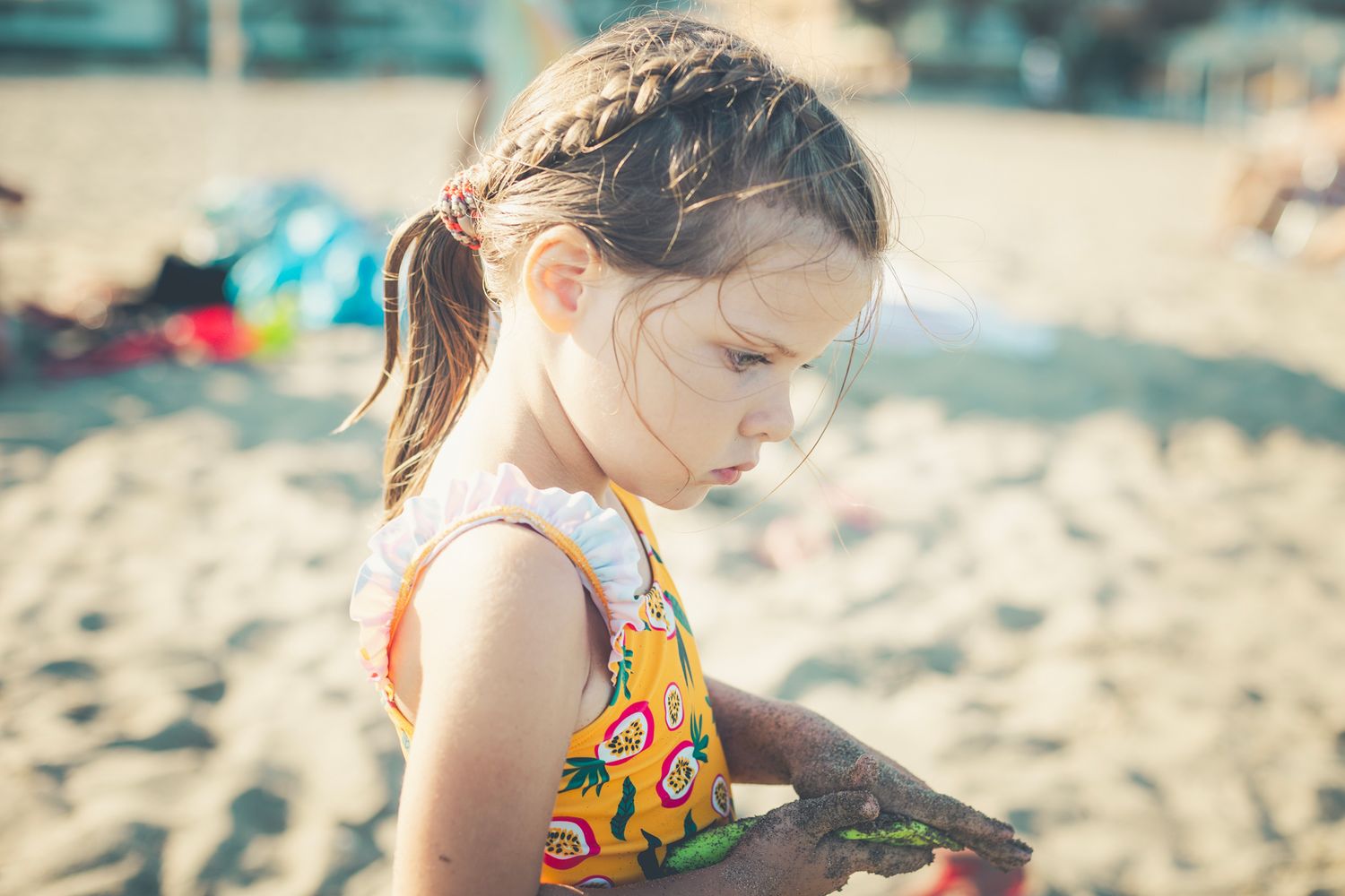 Girl playing with her beach toys on the sand at Marbella beach.