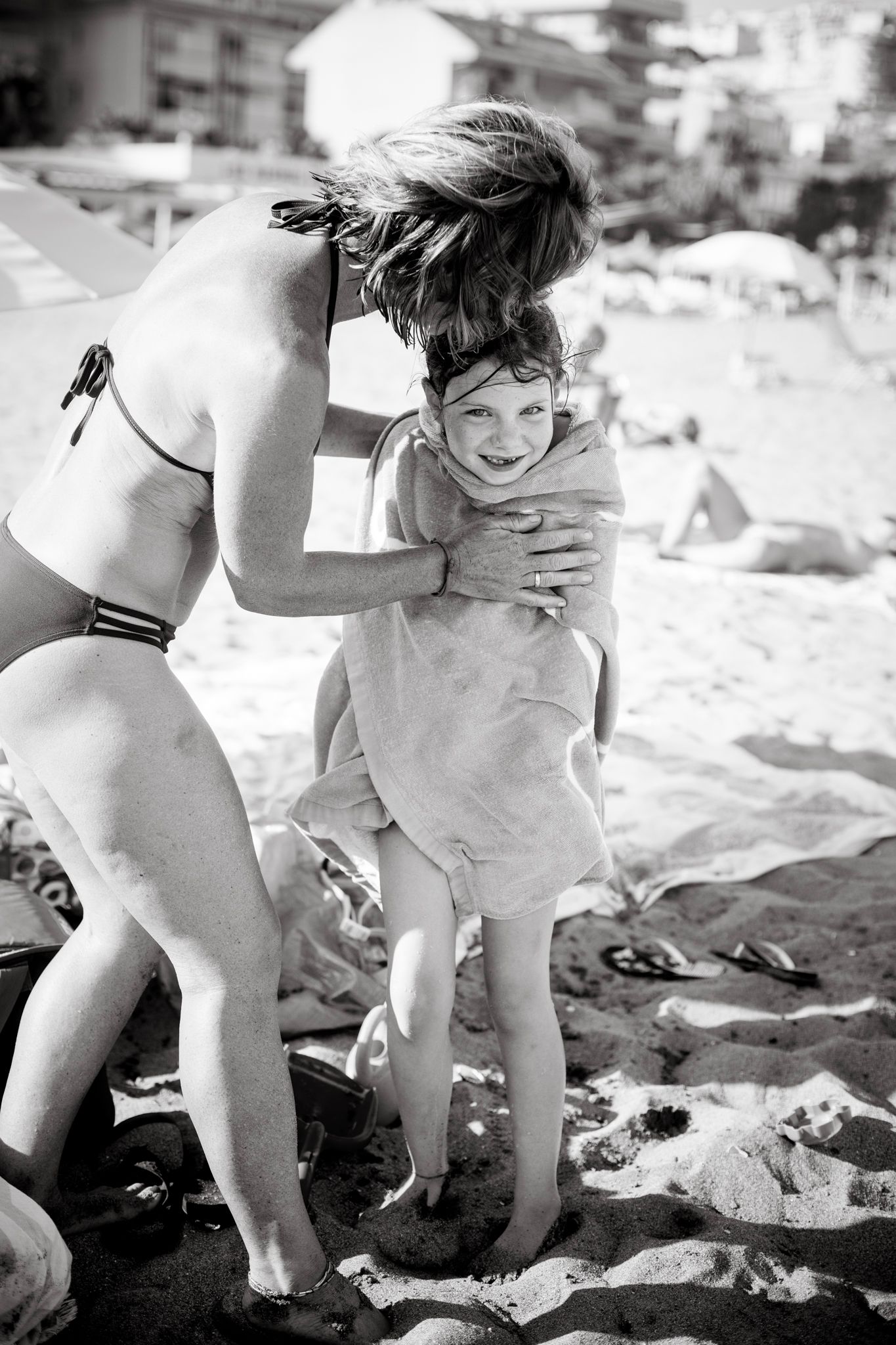 Mom cover her daughter with a towel at Fuengirola beach.