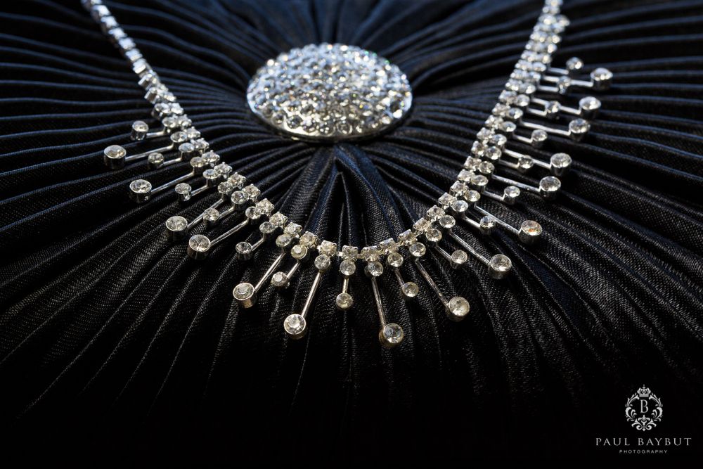 Elegant crystal necklace with intricate design displayed on black fabric.