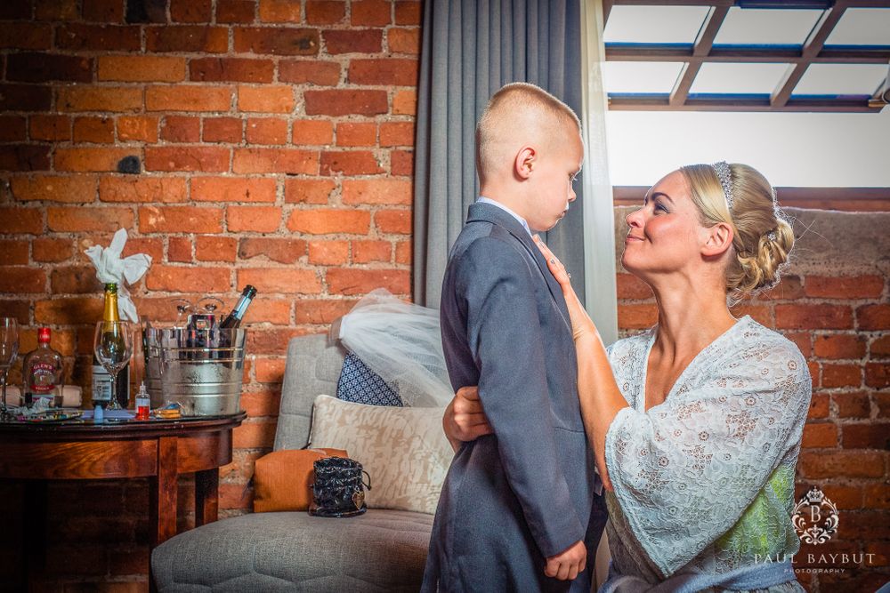 A tender moment shared in front of exposed brick walls with decorative elements in the background.