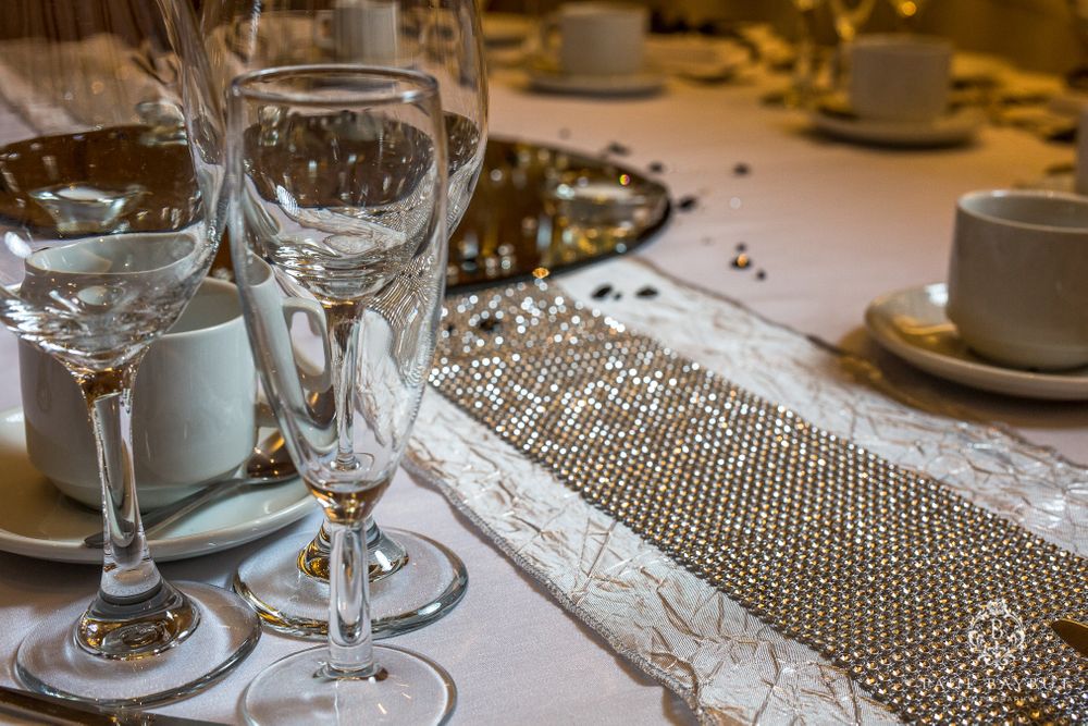 Elegant table setting with crystal wine glasses and sparkling decor at a formal event.