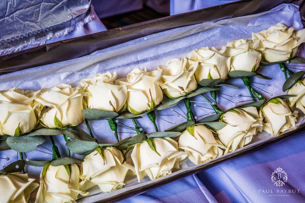 Beautiful cream-colored roses arranged neatly in rows within an elegant display box.