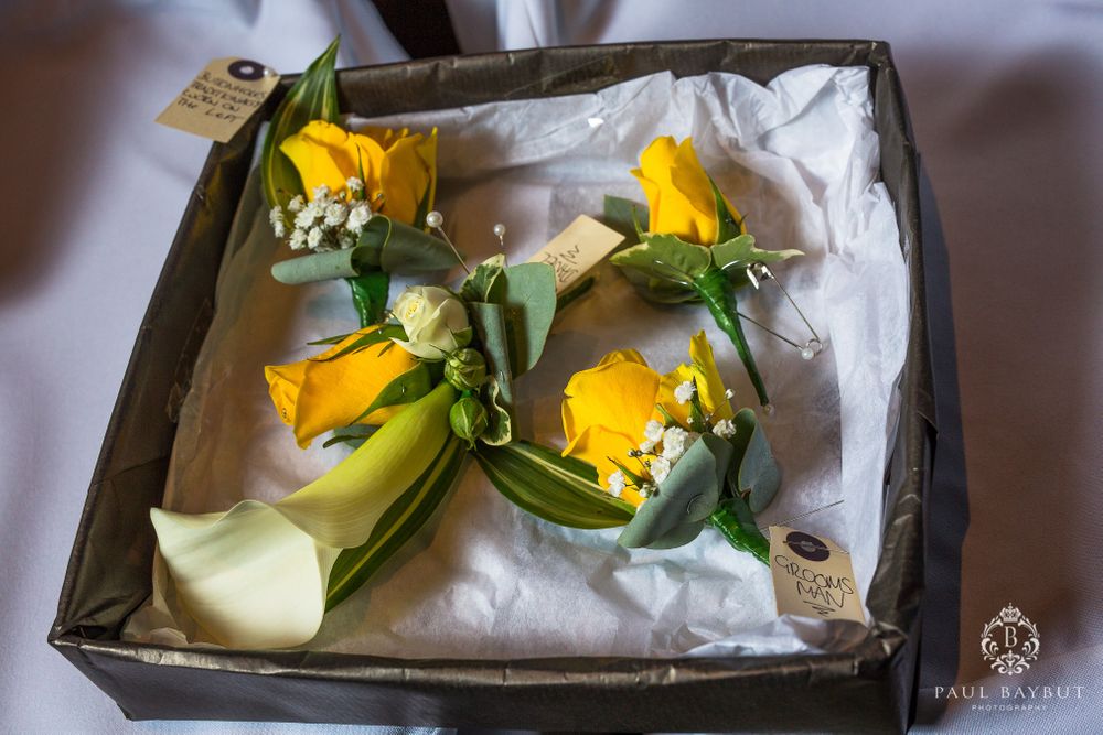 Yellow floral boutonnieres with greenery carefully arranged in a presentation box.