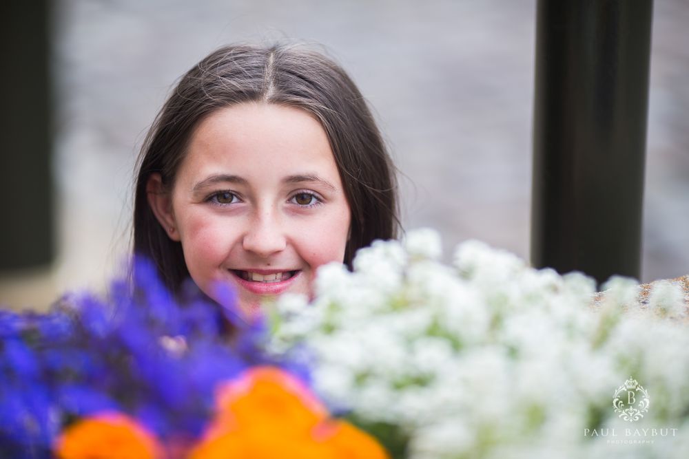 Close up portrait with colorful purple and white flowers in foreground.