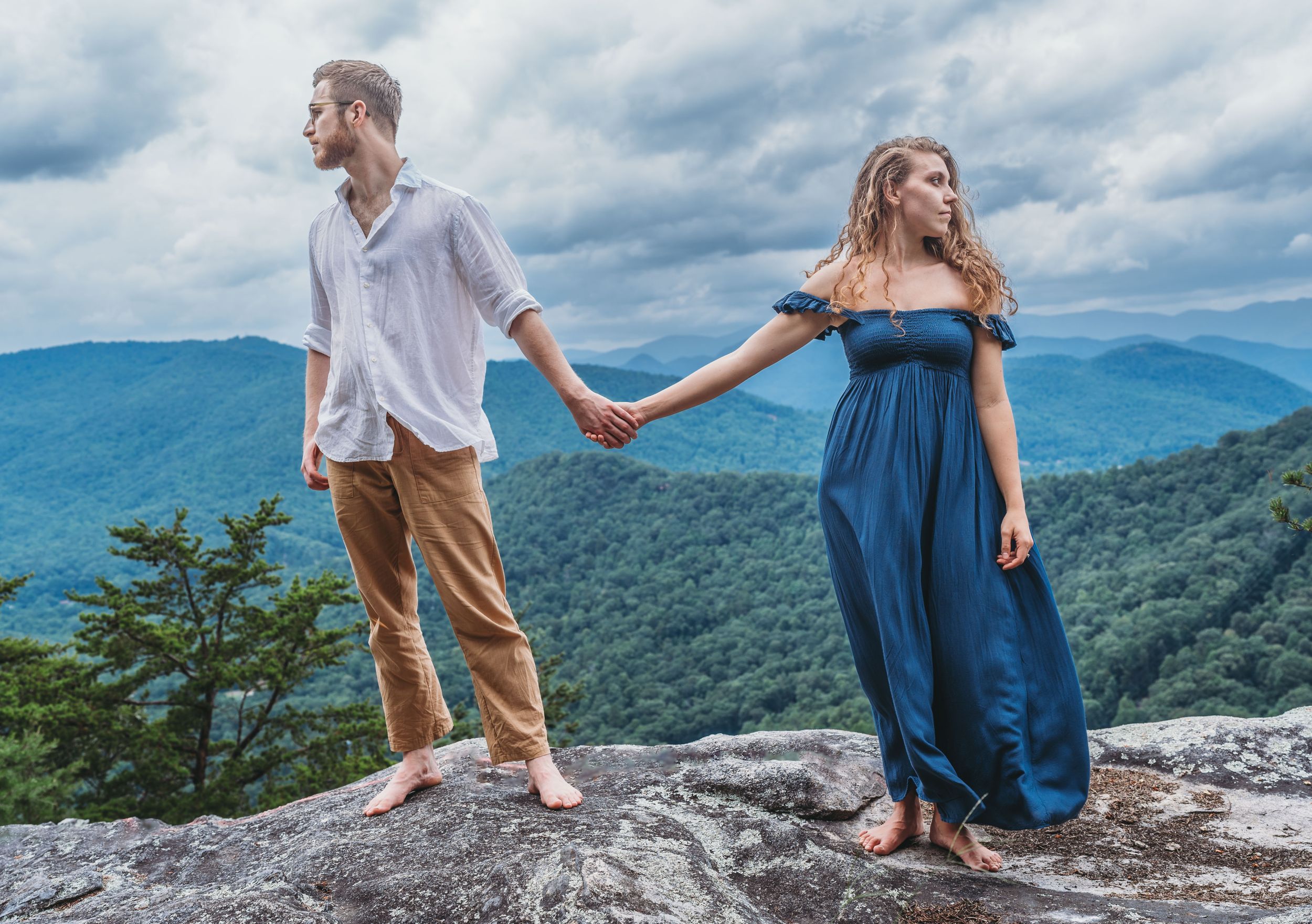 Young engaged couple pose dramatically overlooking the mountains of North Georgia during their photoshoot