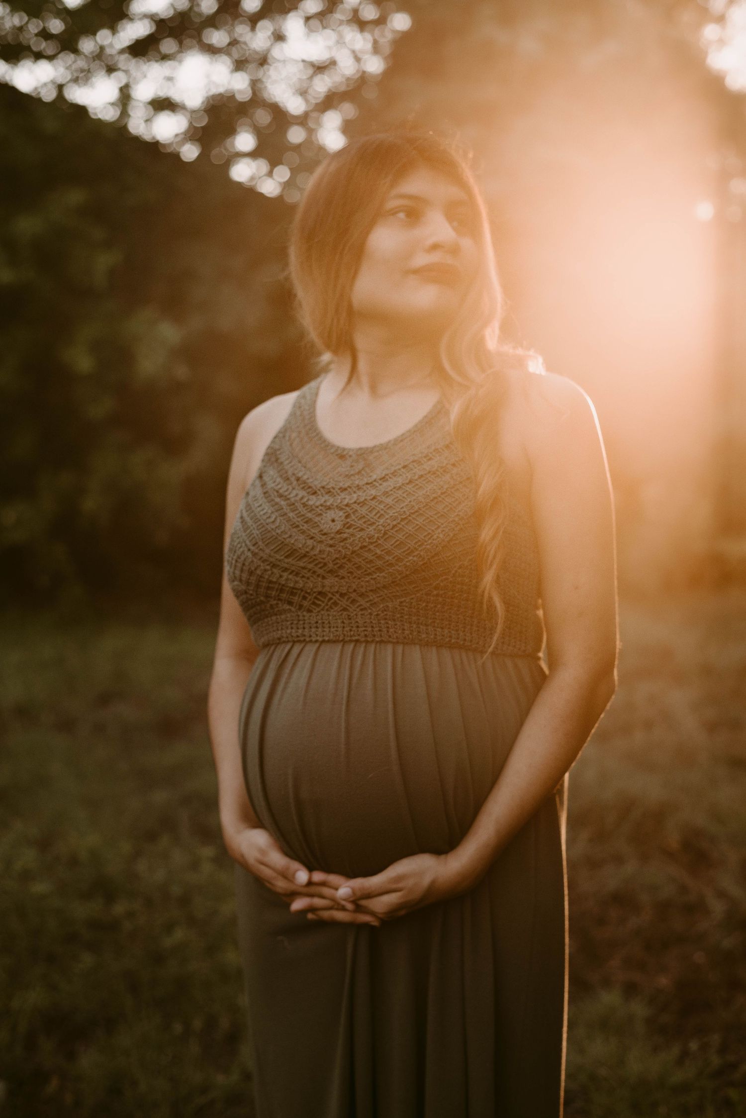 Glowing sunset maternity portrait in olive green dress.
