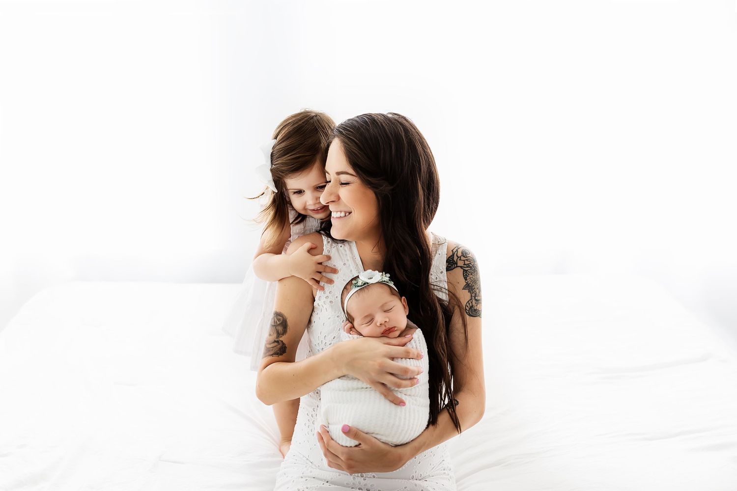 Tender family moment captured in bright white studio setting.