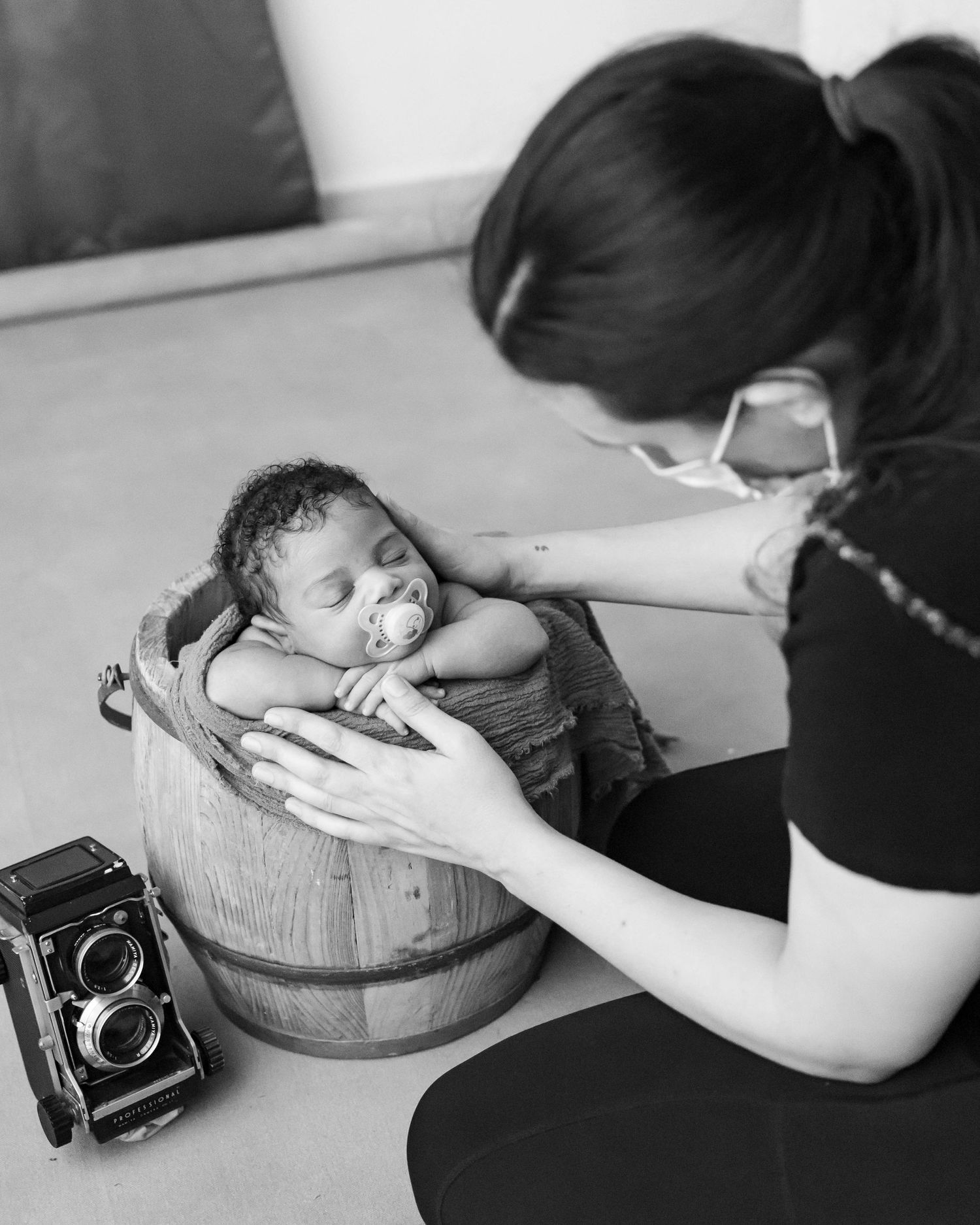 Behind the scenes of newborn photography session with vintage camera.