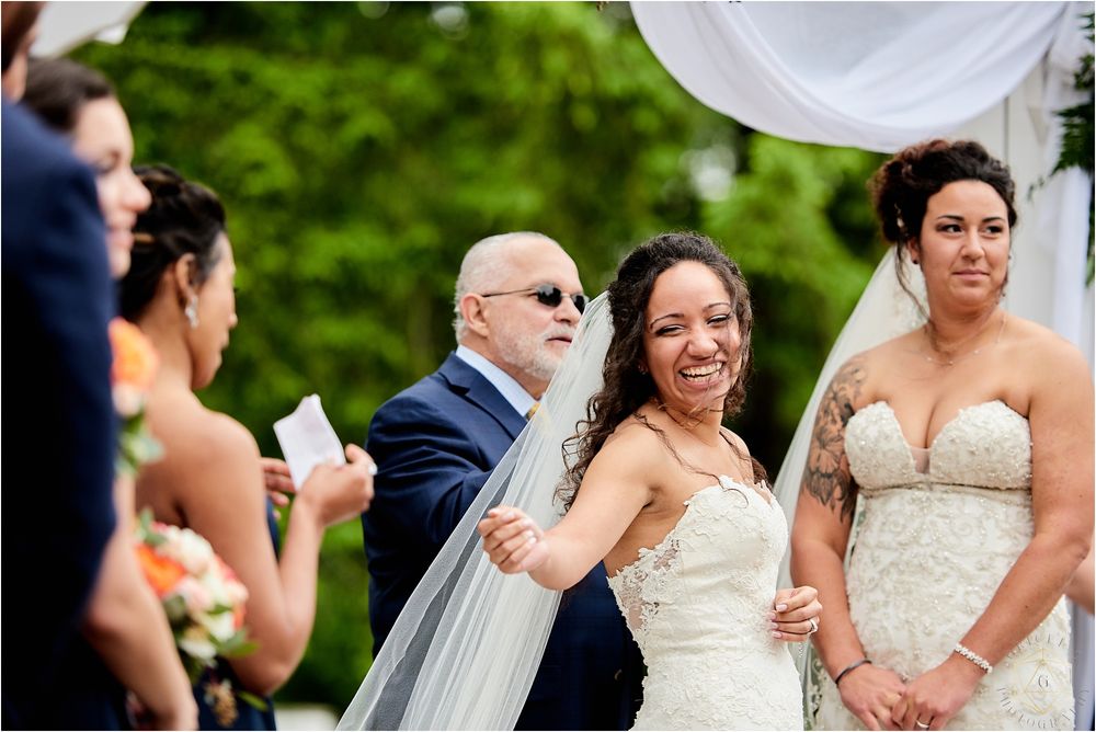 Joyful celebration during an outdoor wedding ceremony under flowing white fabric decorations.