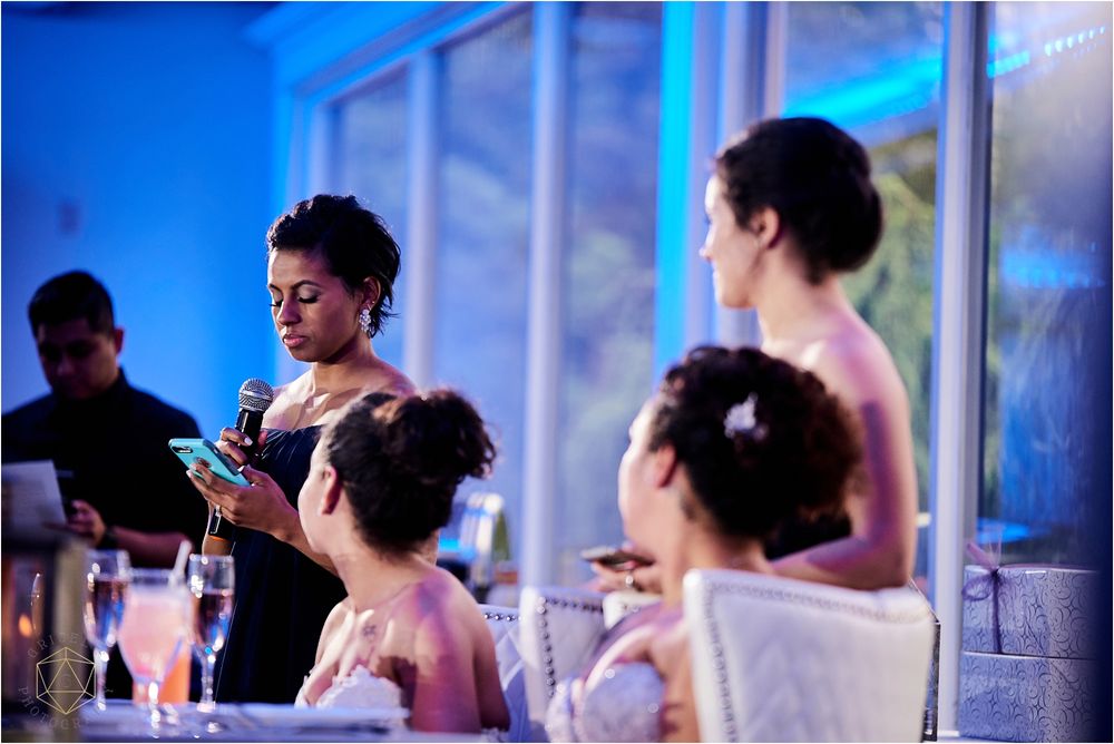 Wedding guests in formal attire enjoying drinks at an elegant reception.