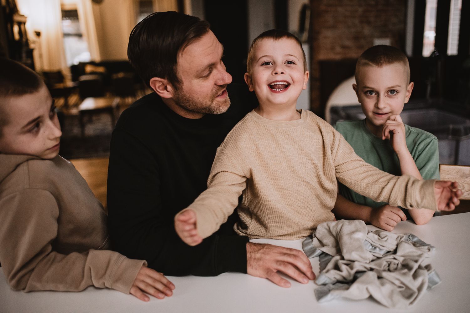 Intimate indoor gathering showing shared moments of joy and laughter around a table.