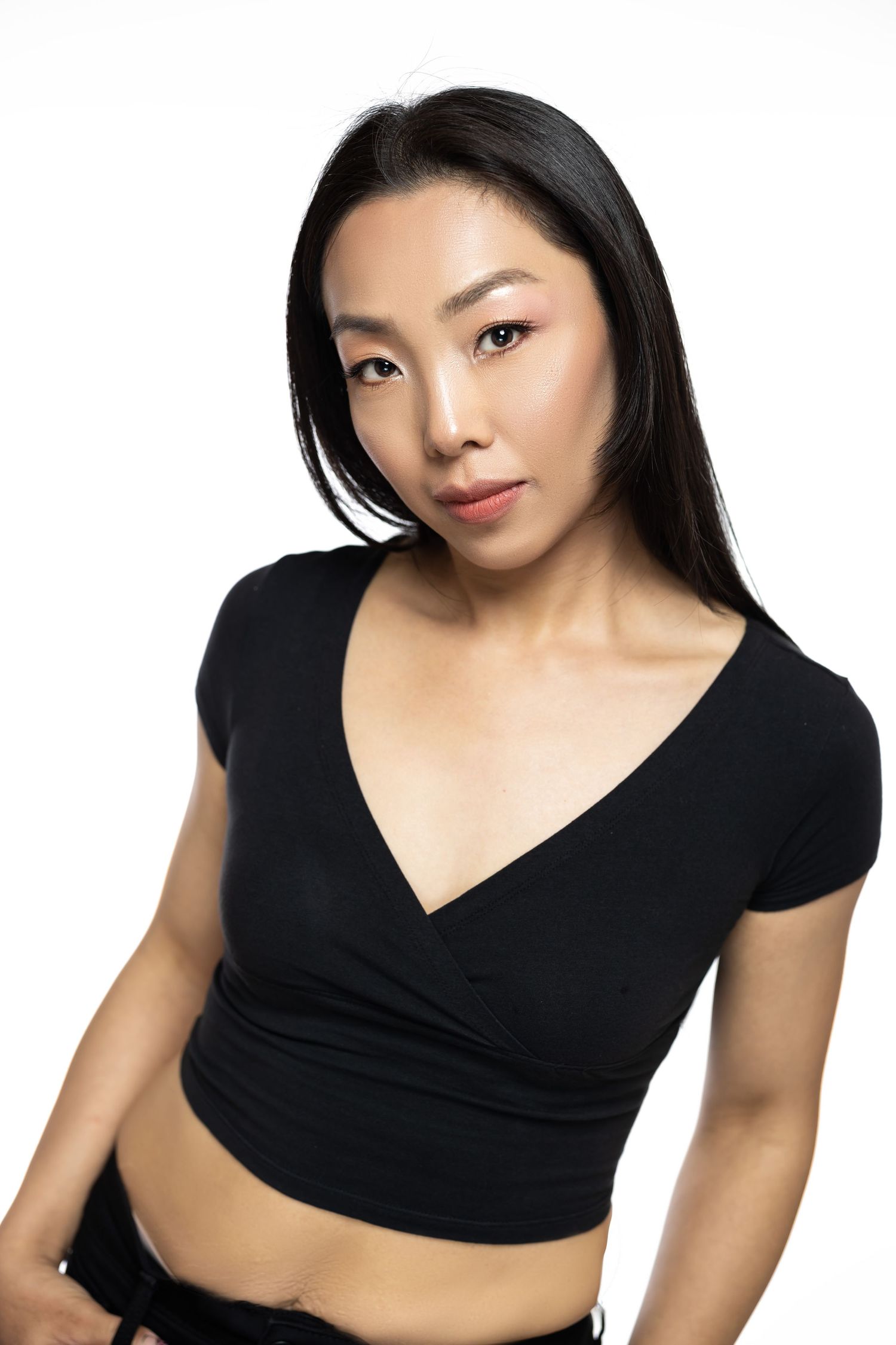 Studio portrait of person wearing black crop top against white background.