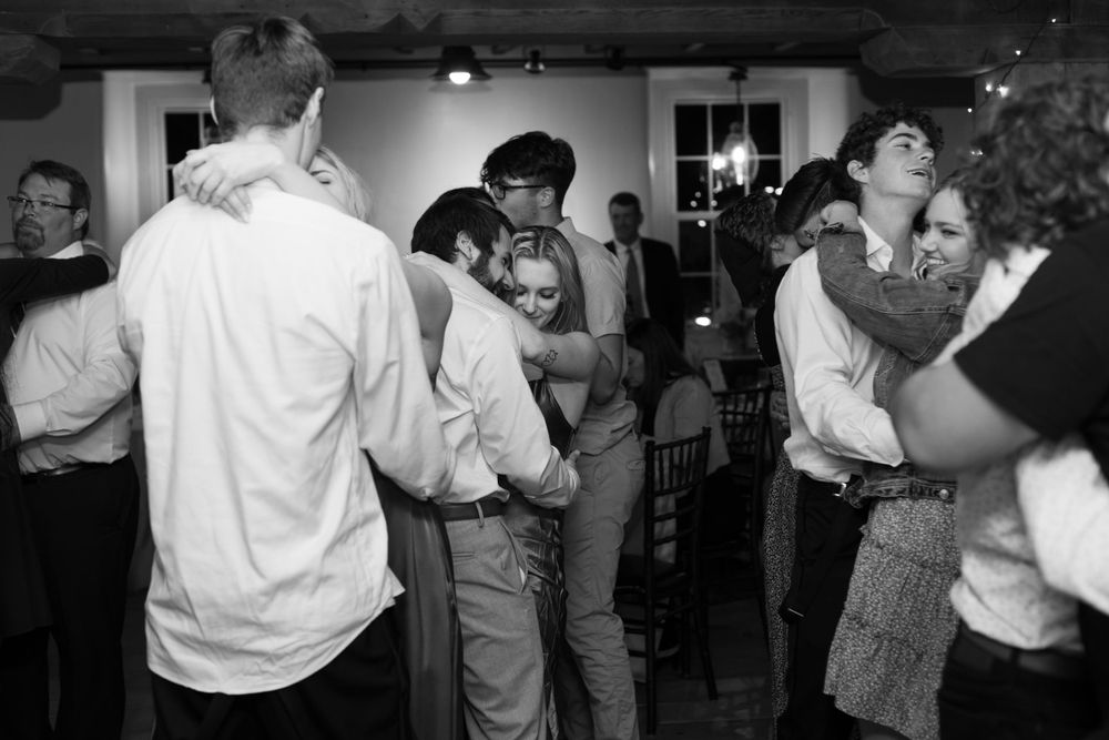 Black and white photo of couples dancing at a lively reception party.
