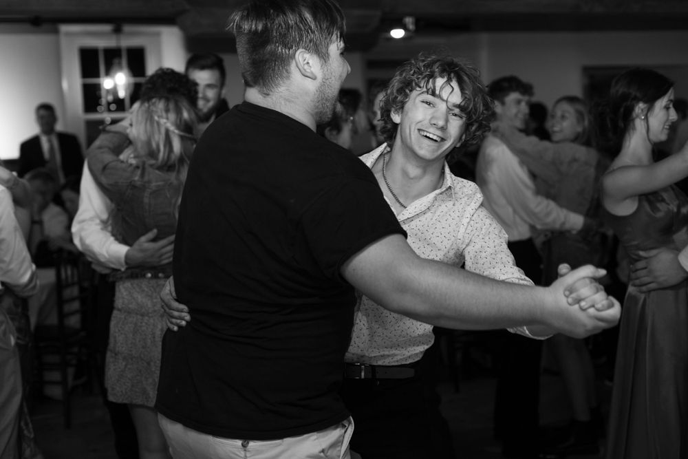 Black and white photo of cheerful dancing at a social gathering.