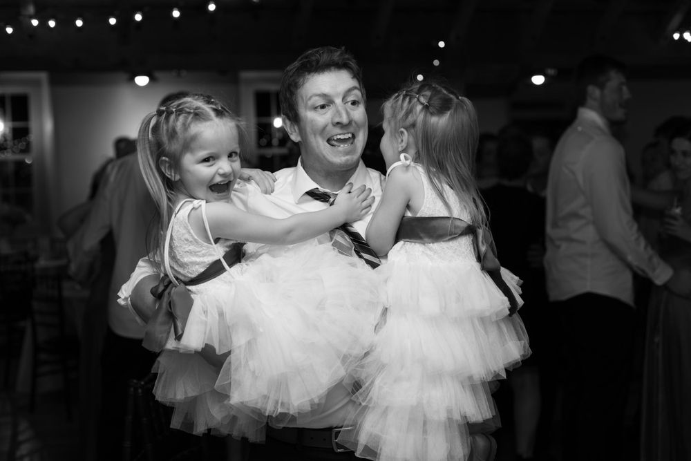 Black and white photo of young children in formal wear dancing at a celebration.