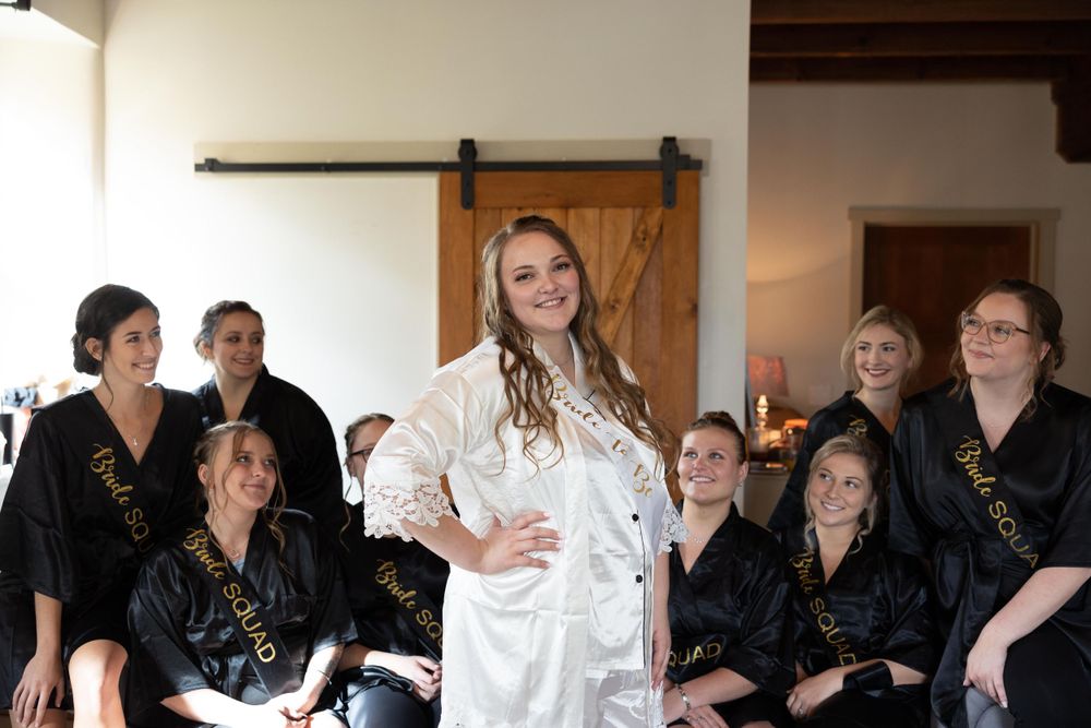 A bridal party gathering in a rustic room with sliding barn door.