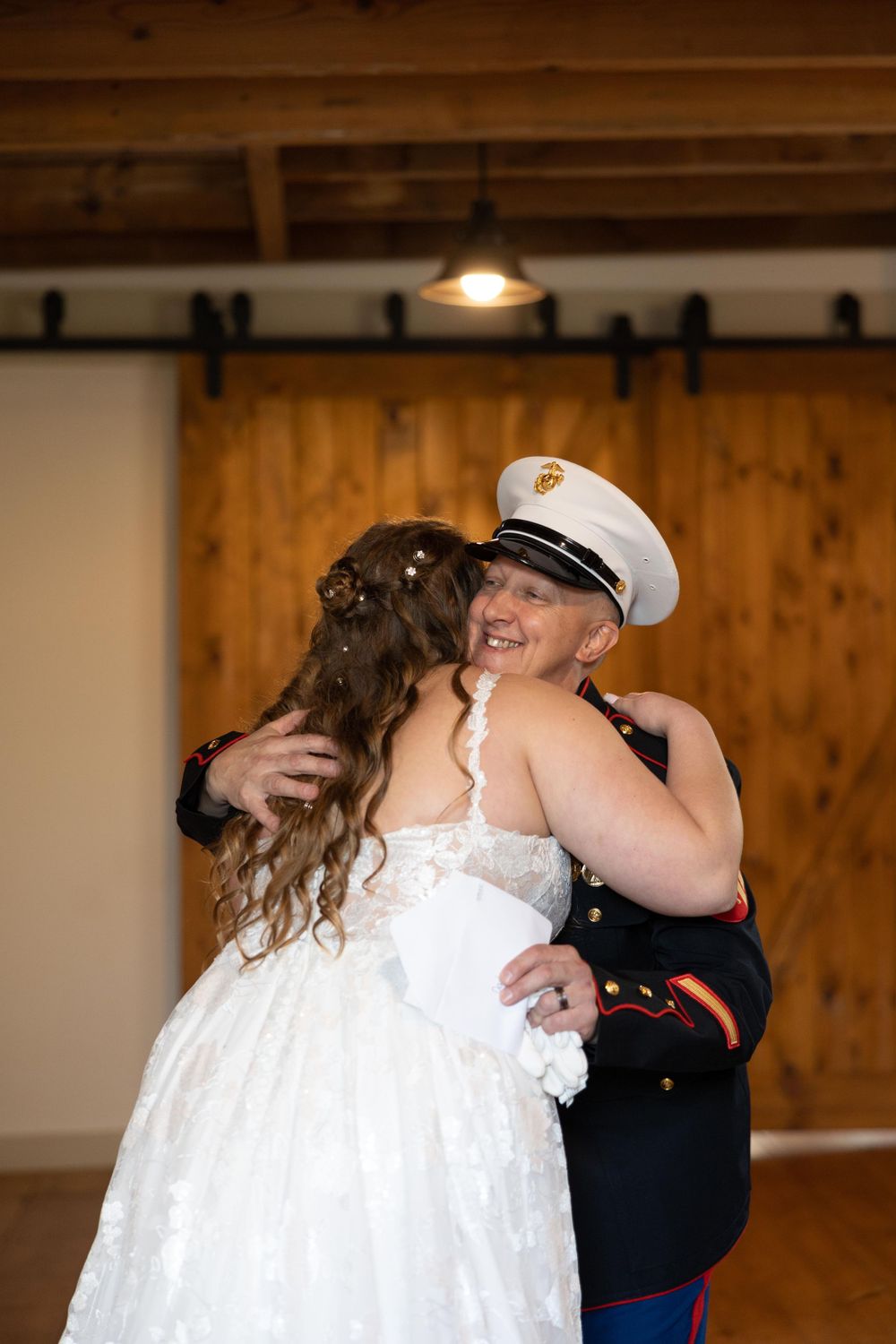 A touching first look moment between a Marine in dress blues and a bride in a white lace gown.