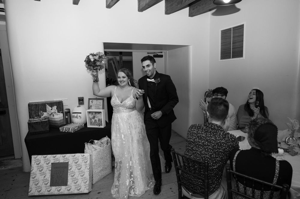 Black and white photograph of a wedding reception entrance at an indoor venue.