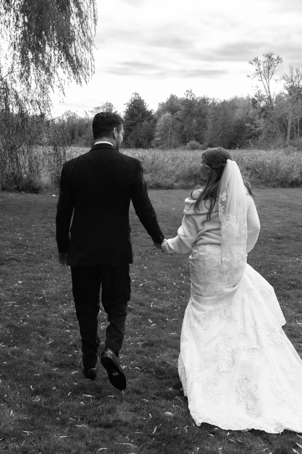 Black and white photo of a bride and groom who were just pronounced married walking away