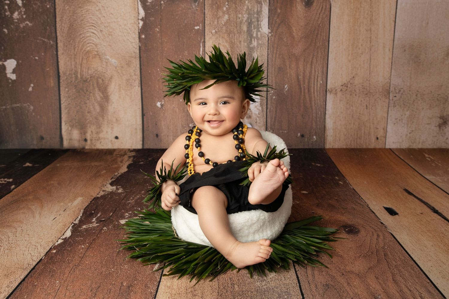 Tropical themed portrait setup with palm leaves and wooden backdrop.