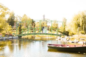 Scenic panorama of park bridge over lake during golden hour.